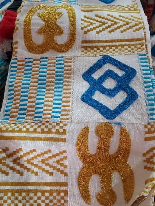 Kente weaving, a beautiful cloth with blue and gold Adinkra signs